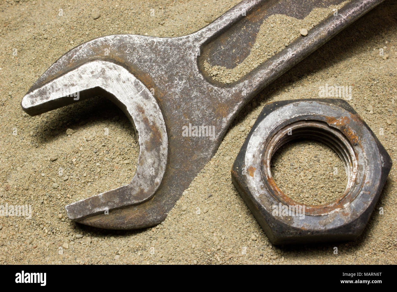Old wrench and nuts on the sand Stock Photo