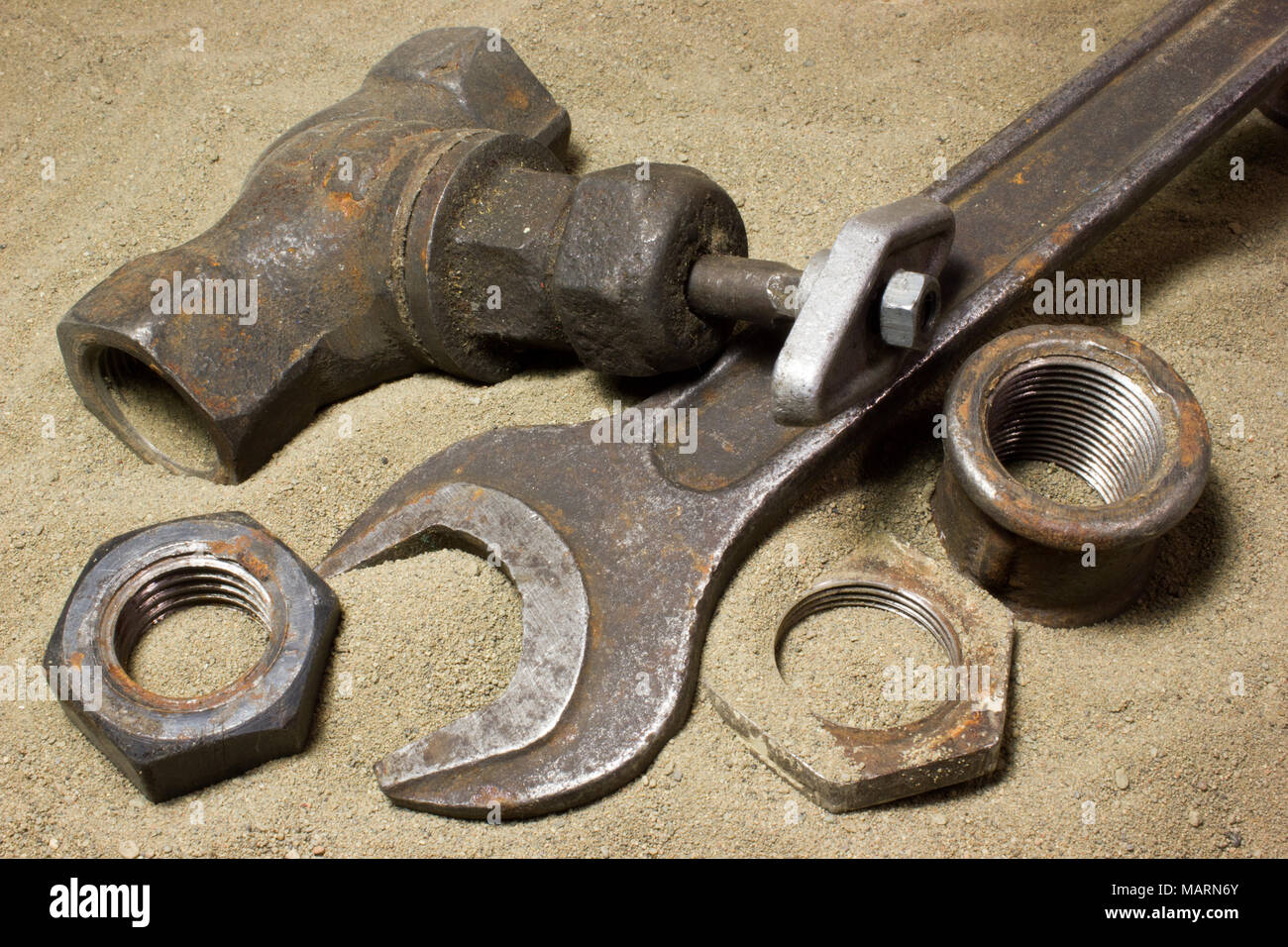 Old wrench and nuts on the sand Stock Photo