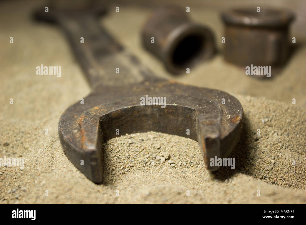 Old wrench and nuts on the sand Stock Photo