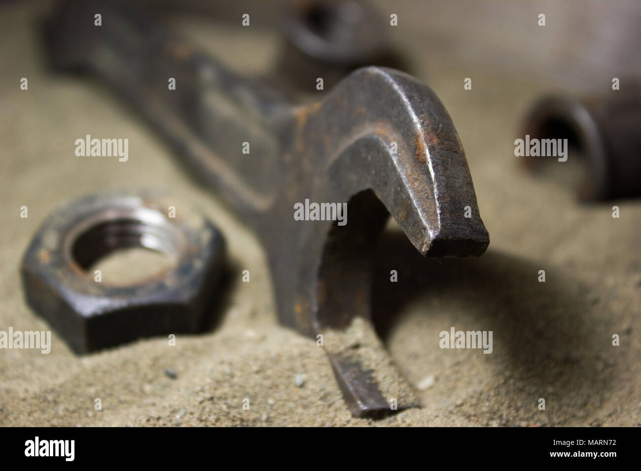 Old wrench and nuts on the sand Stock Photo