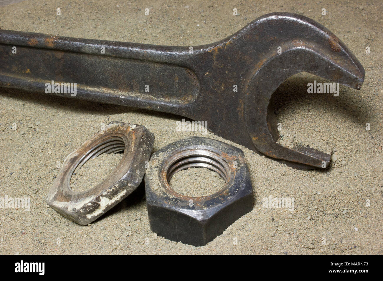 Old wrench and nuts on the sand Stock Photo