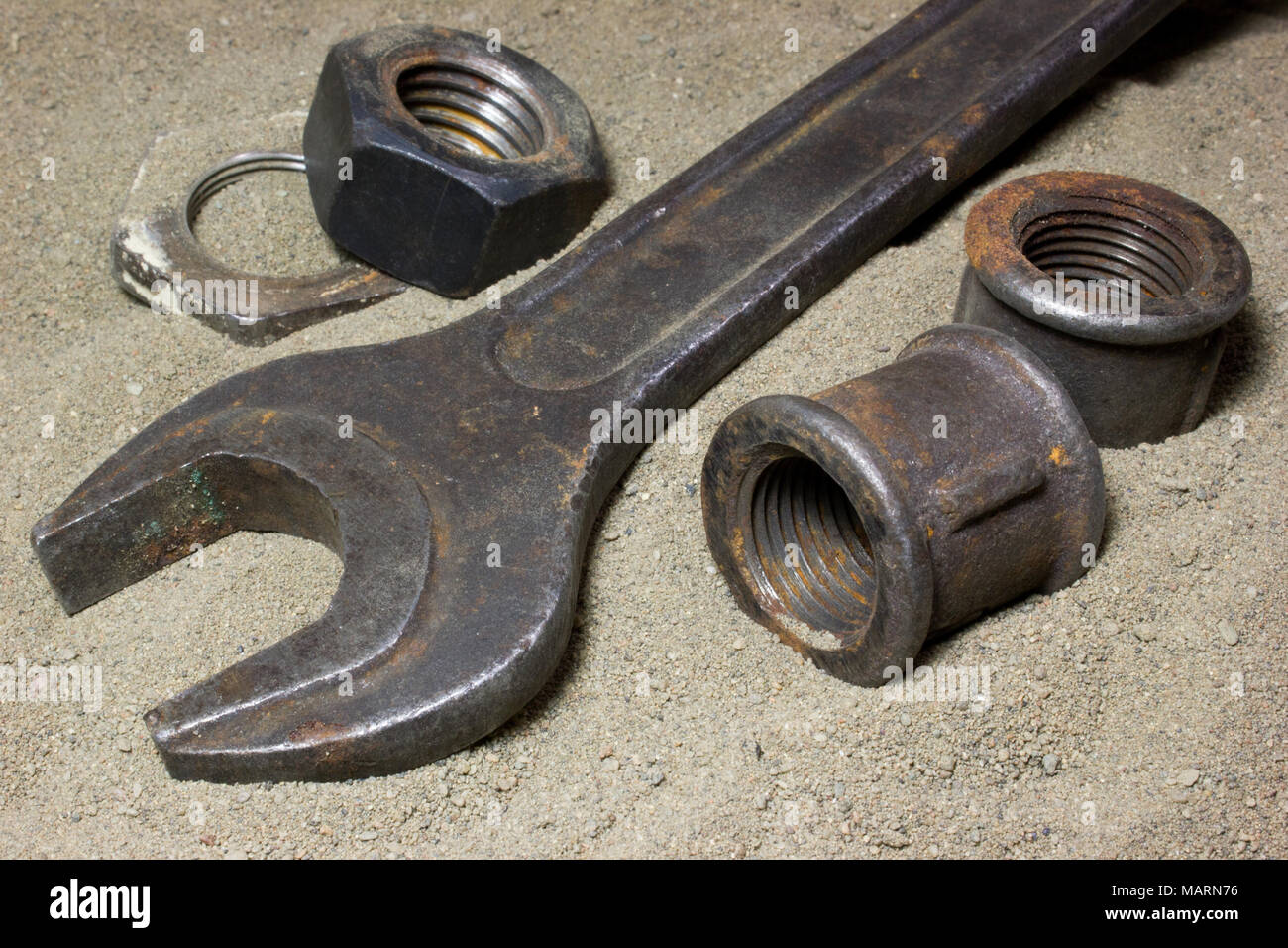 Old wrench and nuts on the sand Stock Photo