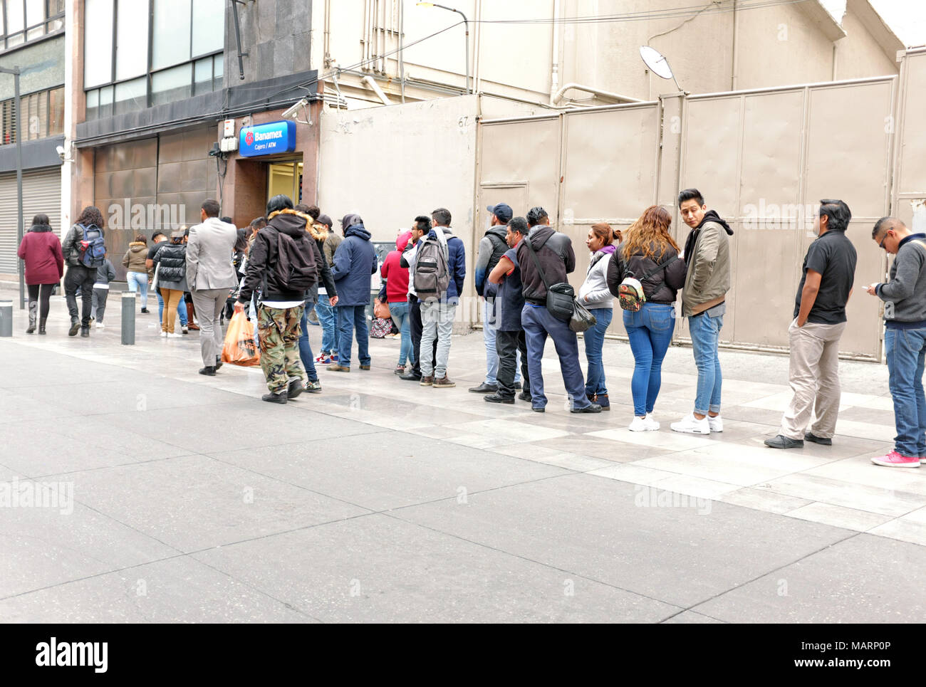 People stand in line waiting to use an ATM bank machine in Mexico City, Mexico on January 30, 2018. Stock Photo