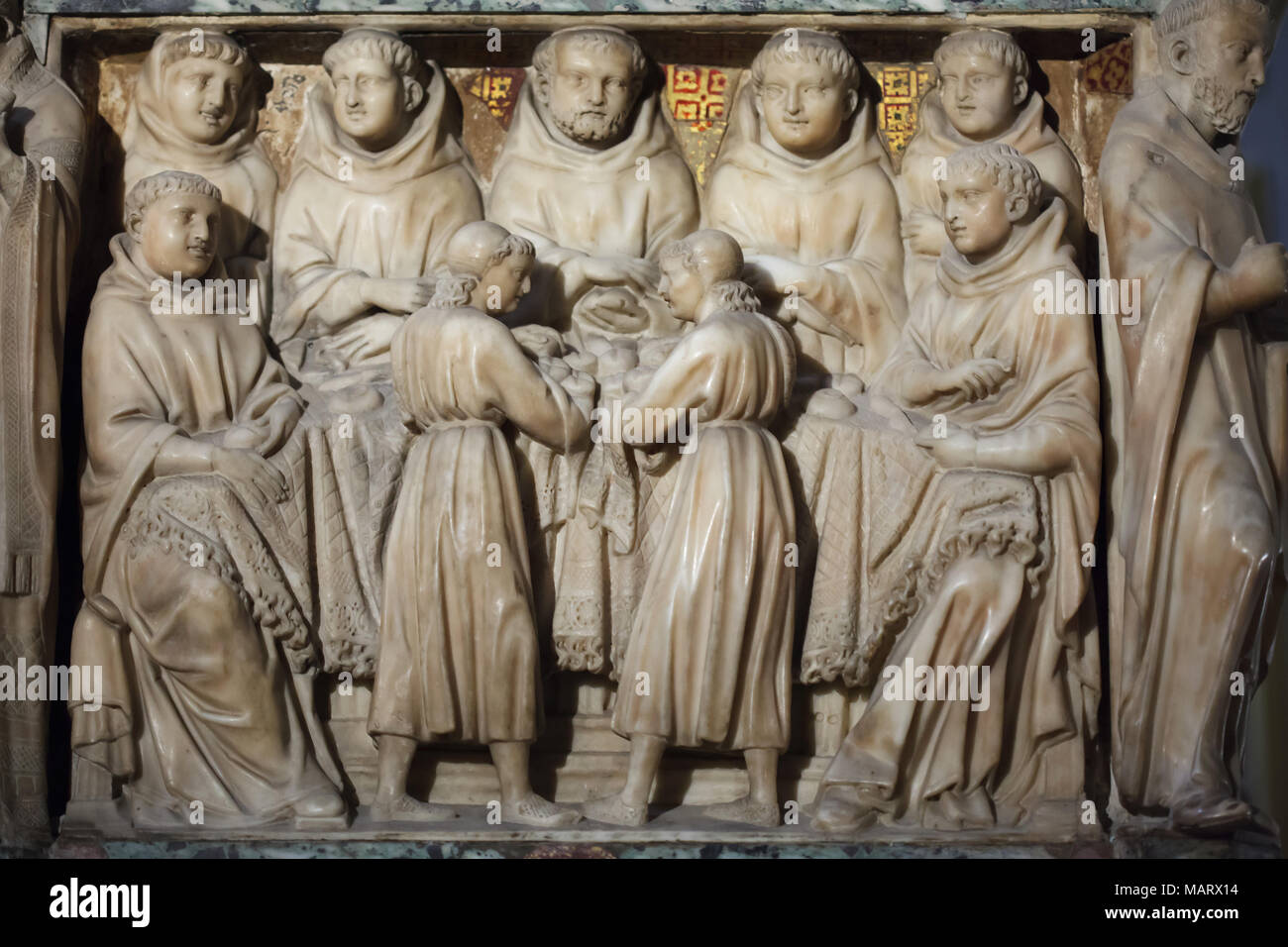 Miracles of Saint Dominic depicted in the marble relief carved by Italian Early Renaissance sculptor Nicola Pisano and his assistants Lapo di Ricevuto and Arnolfo di Cambio (1267) on the Arca di San Domenico (Shrine of Saint Dominic) in the Basilica of San Domenico (Basilica di San Domenico) in Bologna, Emilia-Romagna, Italy. The angels bring bread to the Friars thanks to Saint Dominic's Intercession, representing one of the first miracles of the saint. Stock Photo