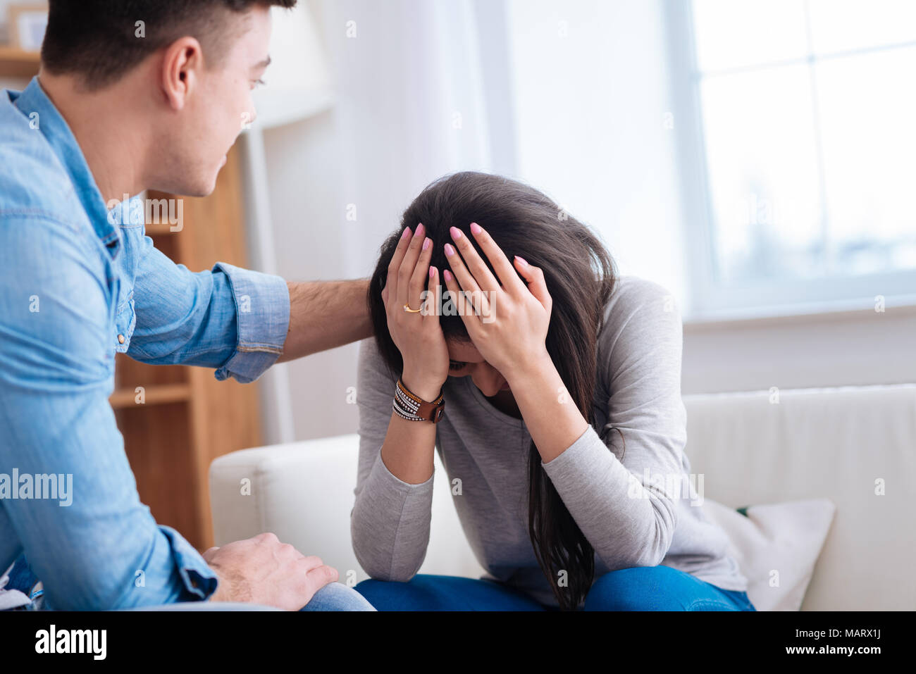 Man calming down upset depressed woman Stock Photo