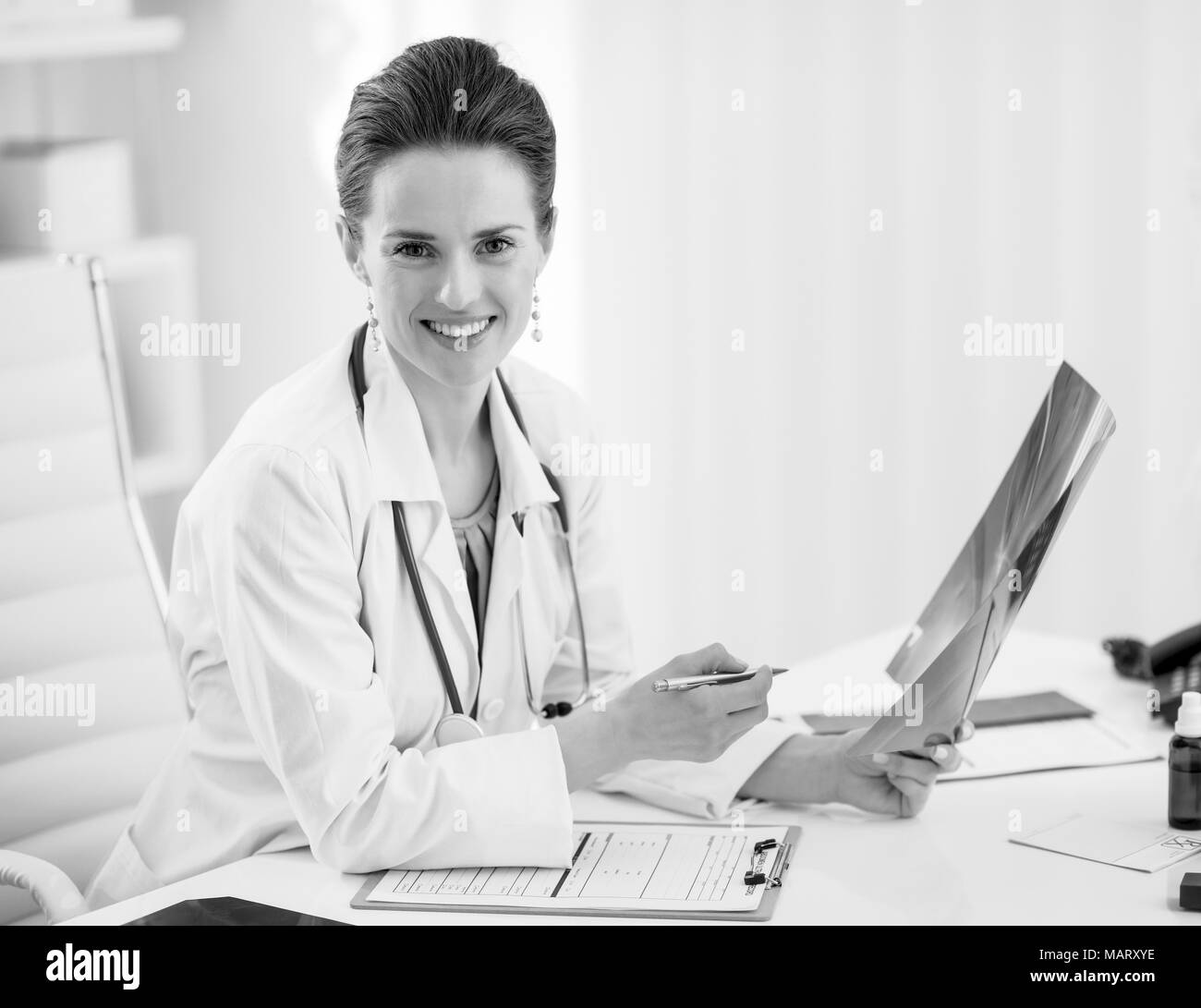 Portrait of happy doctor woman holding fluorography in office Stock Photo
