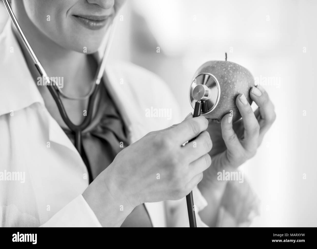 Closeup on doctor woman using stethoscope on apple Stock Photo