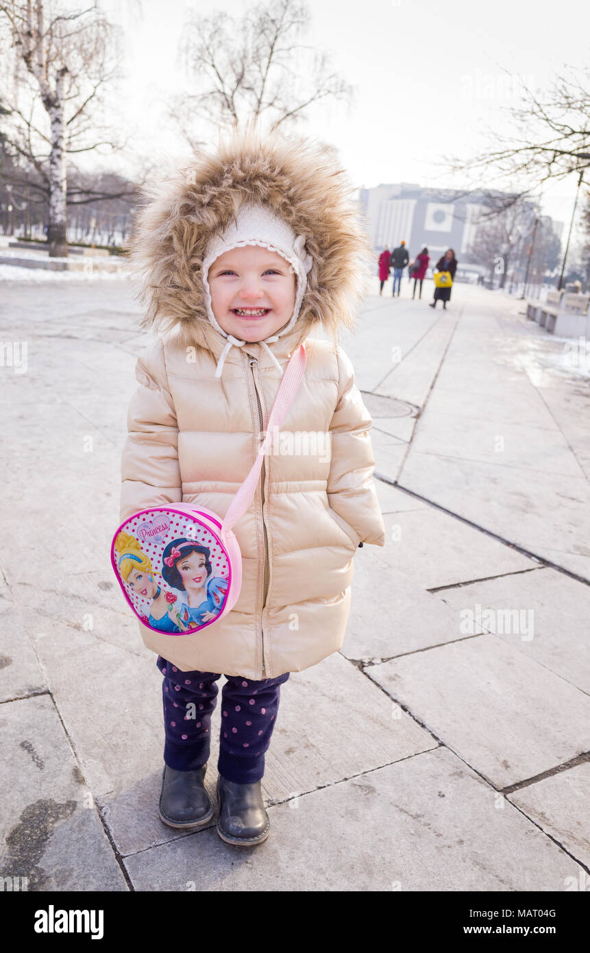 Happy two year old child wearing her fashionable winter coat, Bulgaria Stock Photo