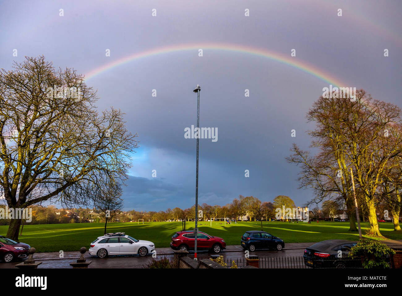 Northampton. UK. 4th Apr, 2018. UK Weather. After a wet and cloudy day the evening clouds are clearing and sunshine  is coming out giving a colourful rainbow over Park Ave South and Abington Park. Credit: Keith J Smith./Alamy Live News Stock Photo