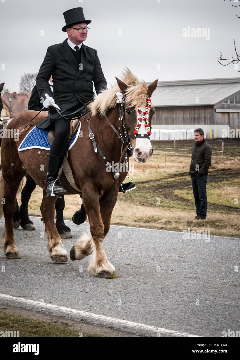 An easter rider taking part in (and a local observer watching) the sorbian Easter Procession on Easter Sunday in Ralbitz, Lausitz, Germany Stock Photo