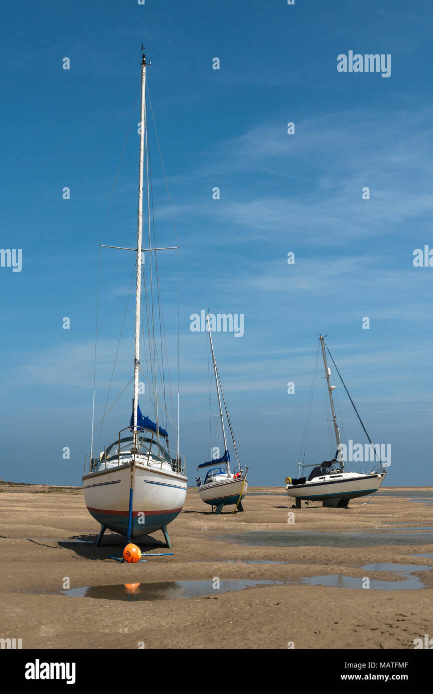 Sailing boats stranded on beach at Red Wharf Bay at low tide Stock Photo
