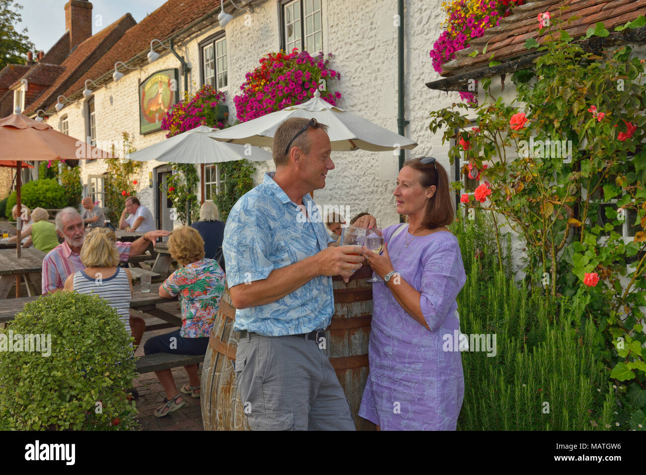 Adult couple drinking outside Tiger Inn, East Dean, East Sussex, England, UK Stock Photo