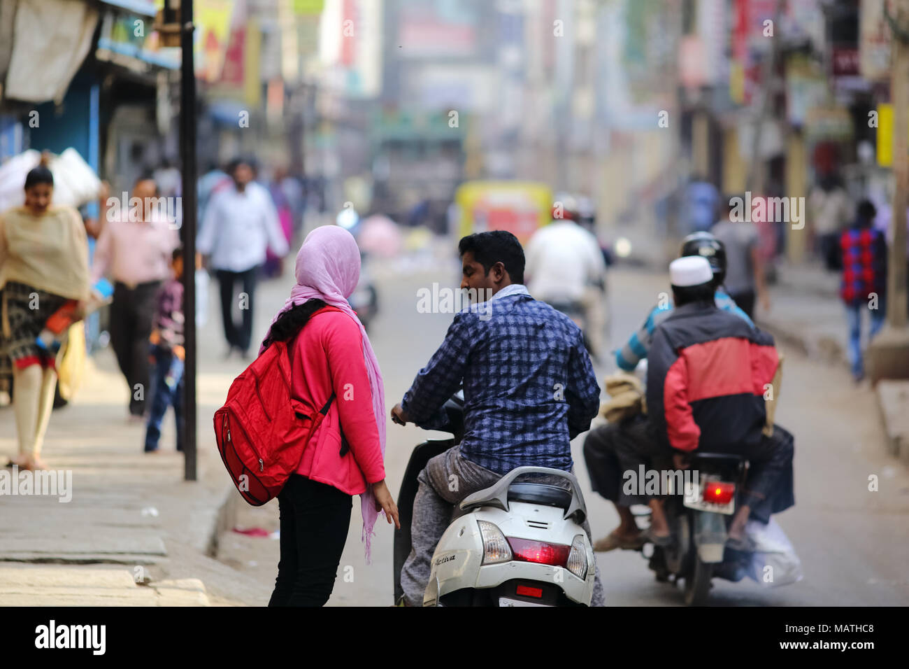 Bangalore, India - October 23, 2016: Unknown lady in casual wear get dropped in a two-wheeler by a man this morning in Avenue road. Stock Photo