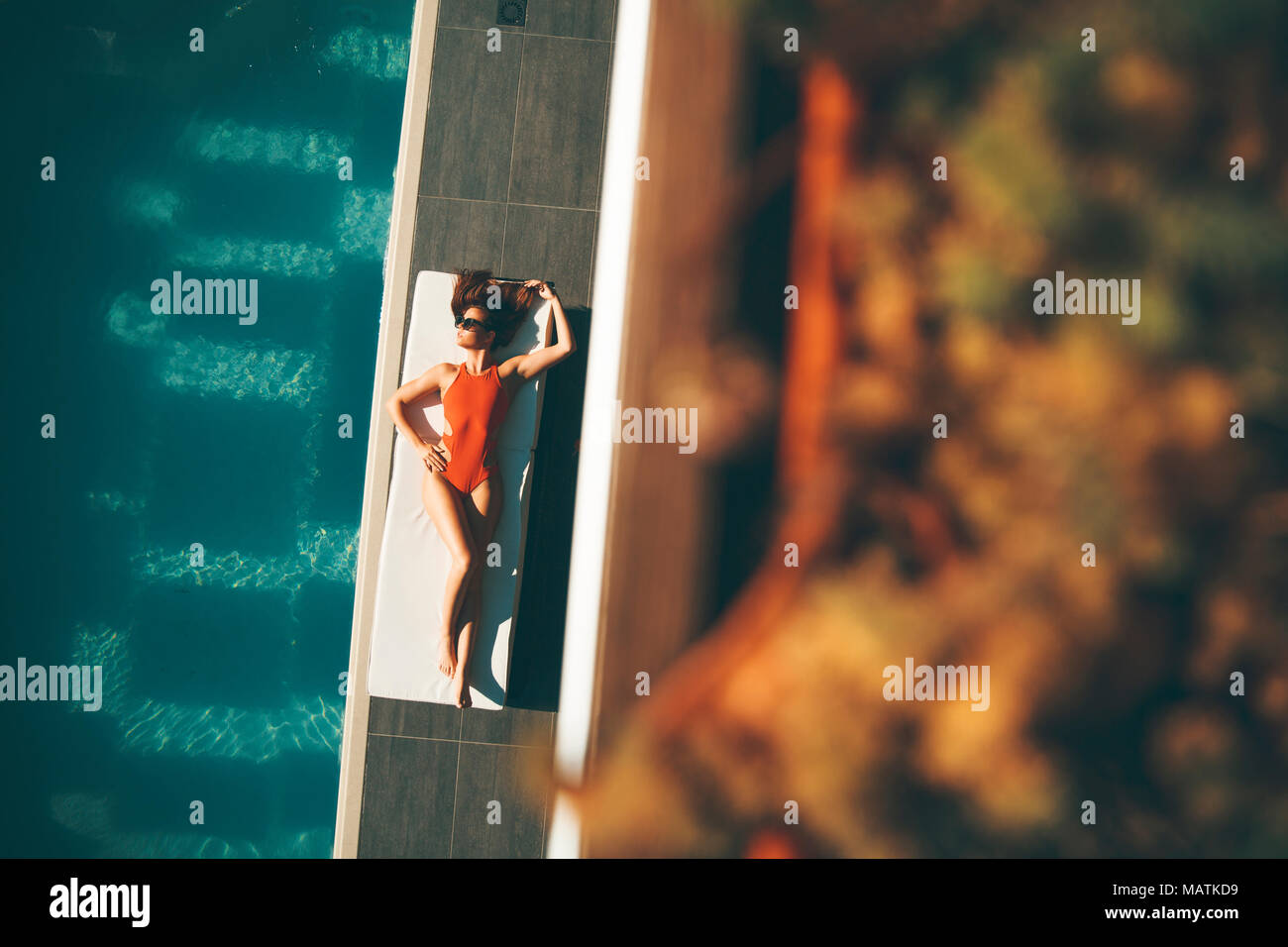 Top view at young slim beautiful woman in swimsuit sunbathing near swimming pool Stock Photo