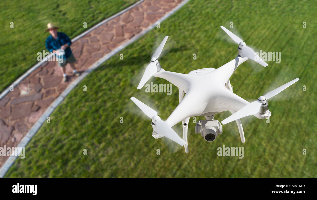 Drone Quadcopter (UAV) In Air Above Pilot With Remote Controller. Stock Photo