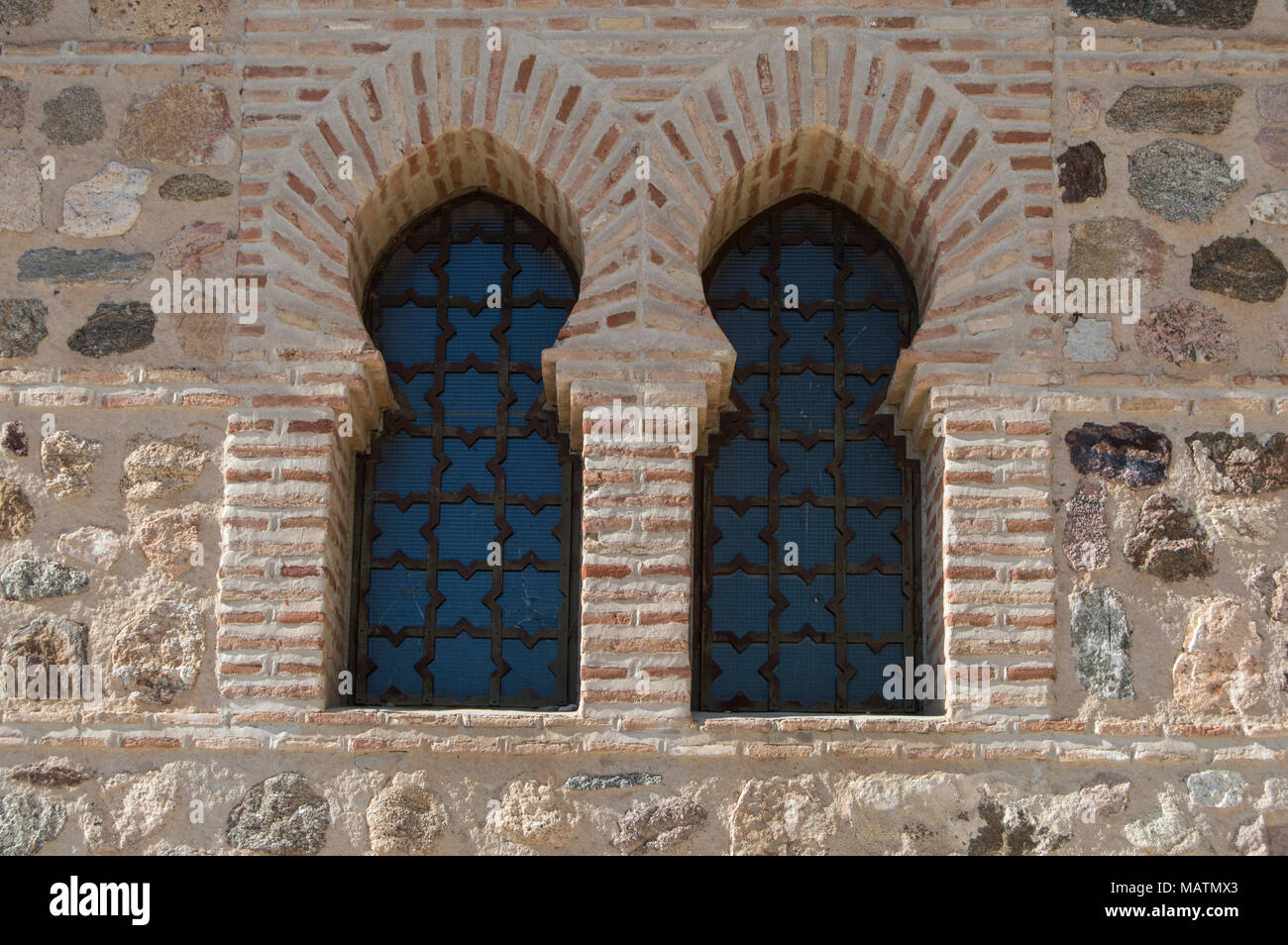 double window with pointed horseshoe arch in Visigothic style on a brick wall in a facade of a church. Stock Photo