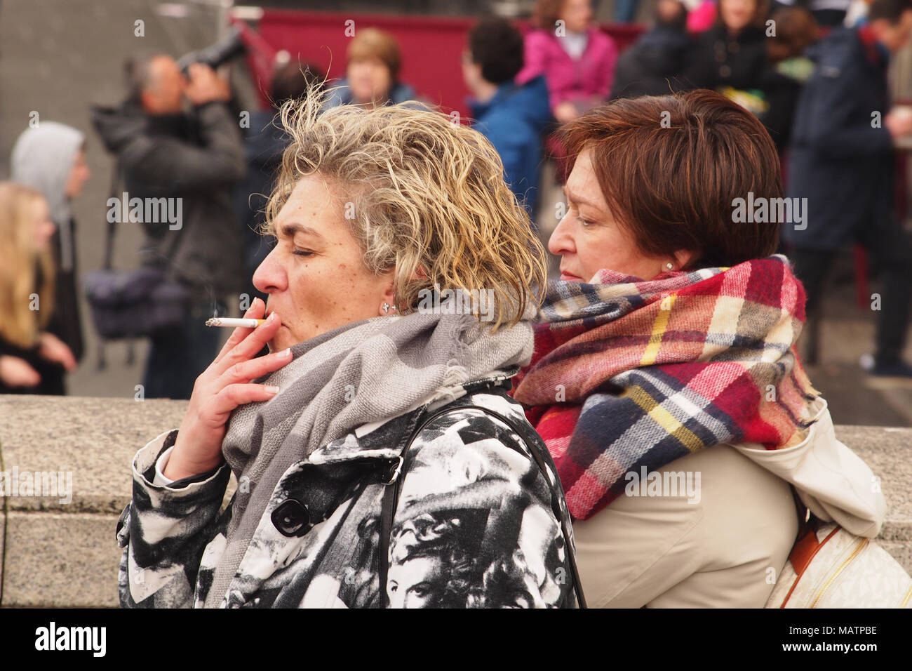 Two women smoking cigarettes sightseeing in London on a cold winter day Stock Photo