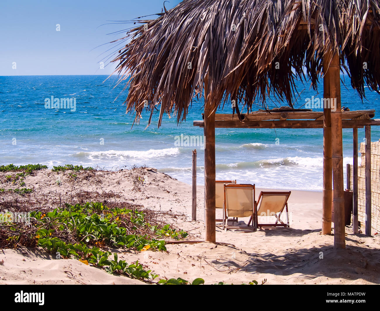 Beach chairs with natural umbrella in the pacific ocean, Mancora, Peru CAMERA Stock Photo