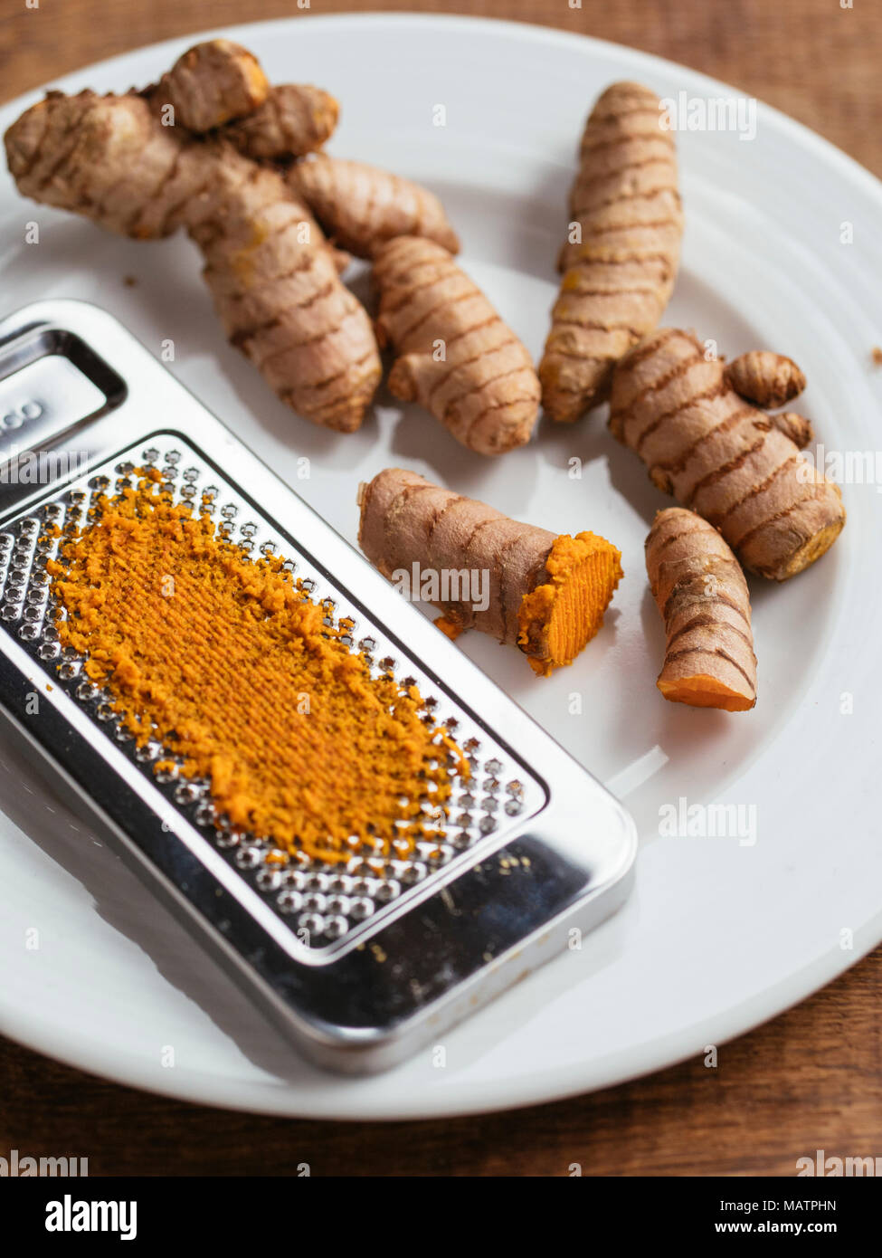 Freshly grated turmeric and turmeric roots. Stock Photo