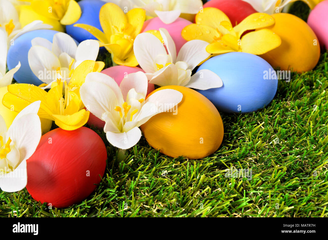 Easter background with hand painted eggs hidden in flowers Stock Photo