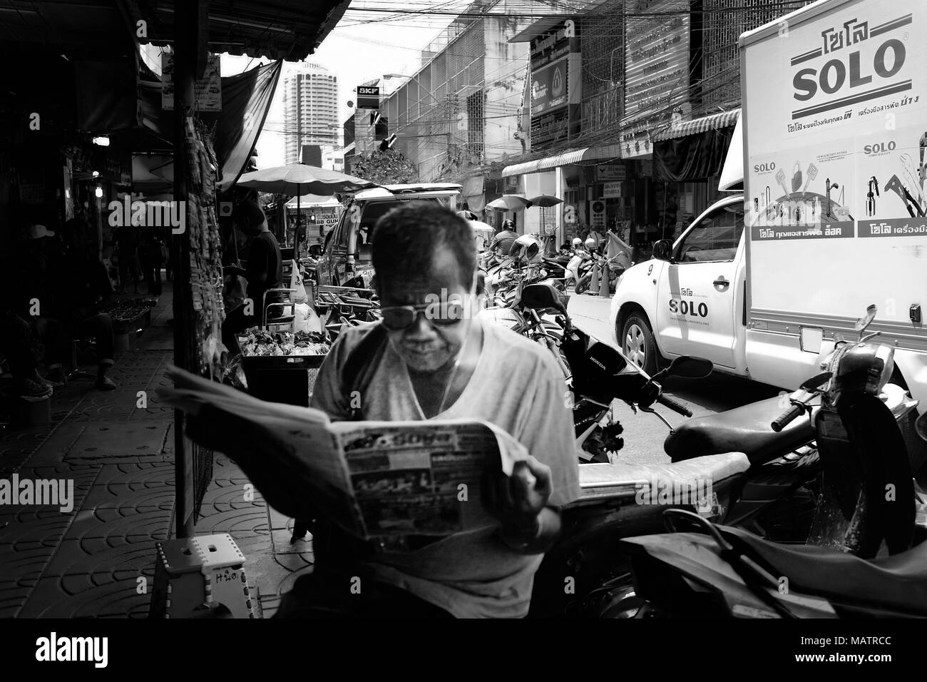 Man having a peaceful moment reading the newspaper, Bangkok Stock Photo