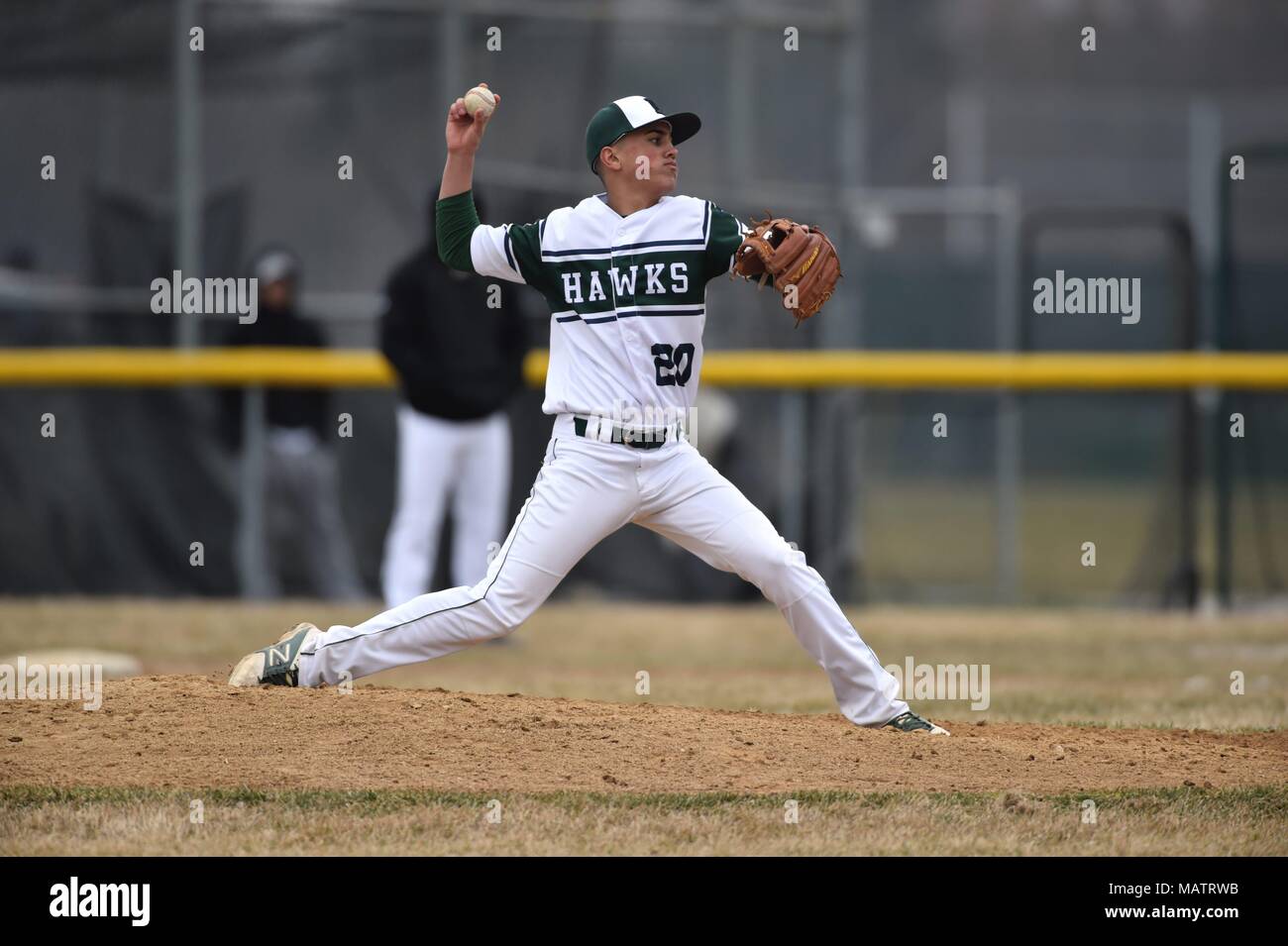 Pitcher delivering a pitch to an opposing hitter during a high school