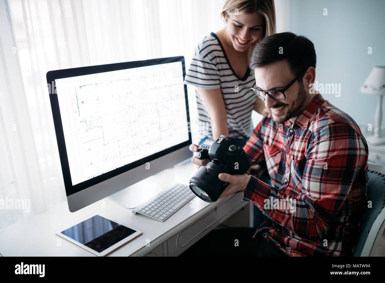 Young attractive designers working on project together Stock Photo