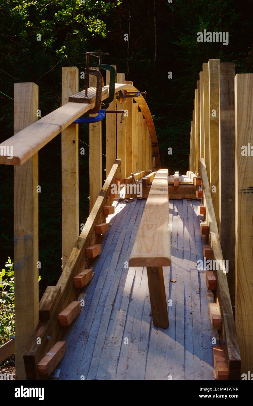 15 in a series of 32, building a timber footbridge. Posts installed with step supports visible and handrails being prepared for fitting Stock Photo
