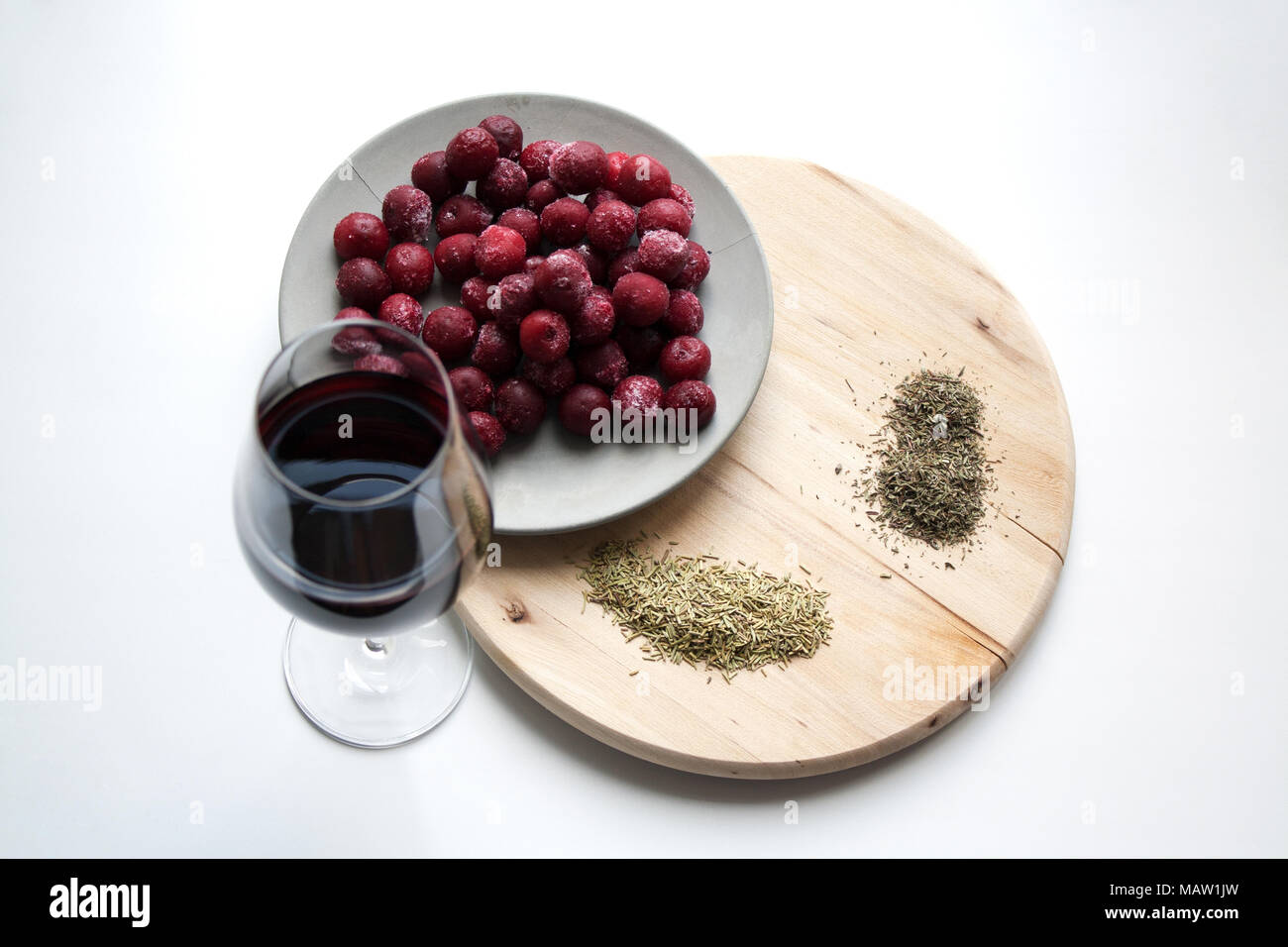 Cherries and wine, rosemary and thyme composition isolated on white
