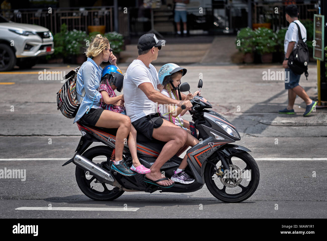 Family Motorcycle. Mother father and two children traveling on a moped motorcycle Thailand Southeast Asia Stock Photo