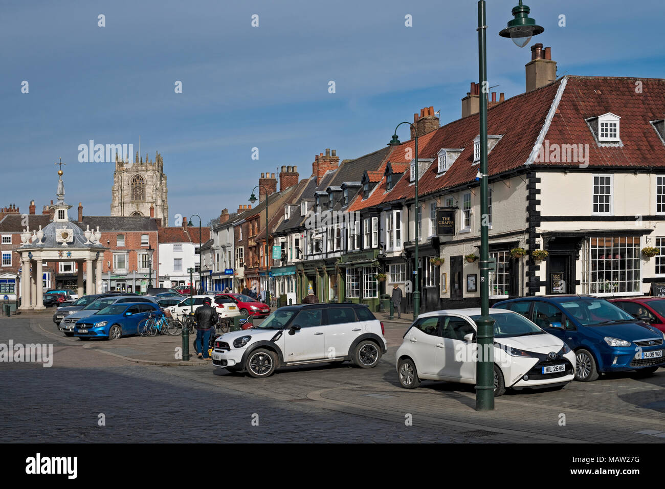 Cars parked in the Market Square and Market Cross in spring Beverley town centre East Yorkshire England UK United Kingdom GB Great Britain Stock Photo