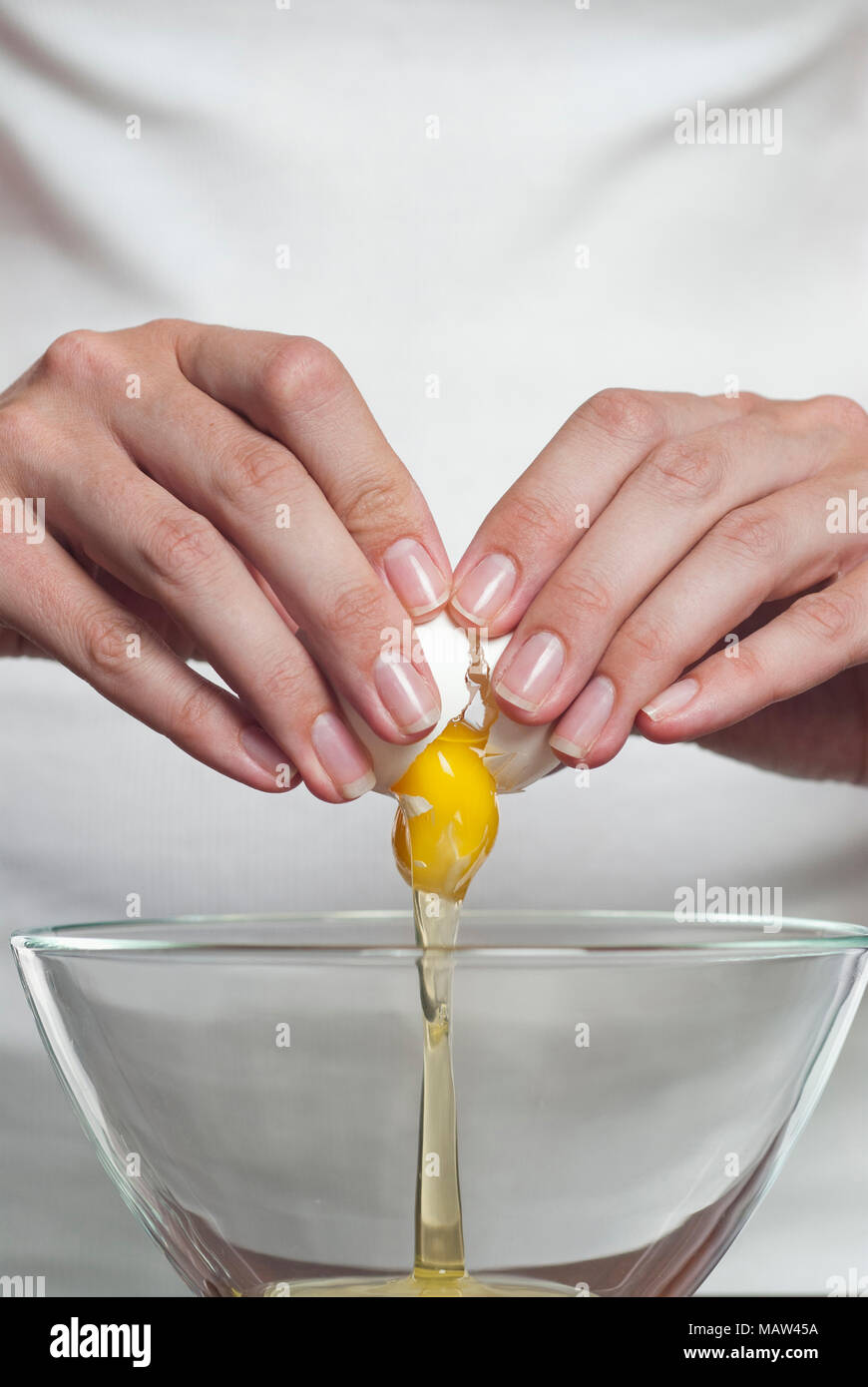 A womans hands cracking an egg Stock Photo Alamy