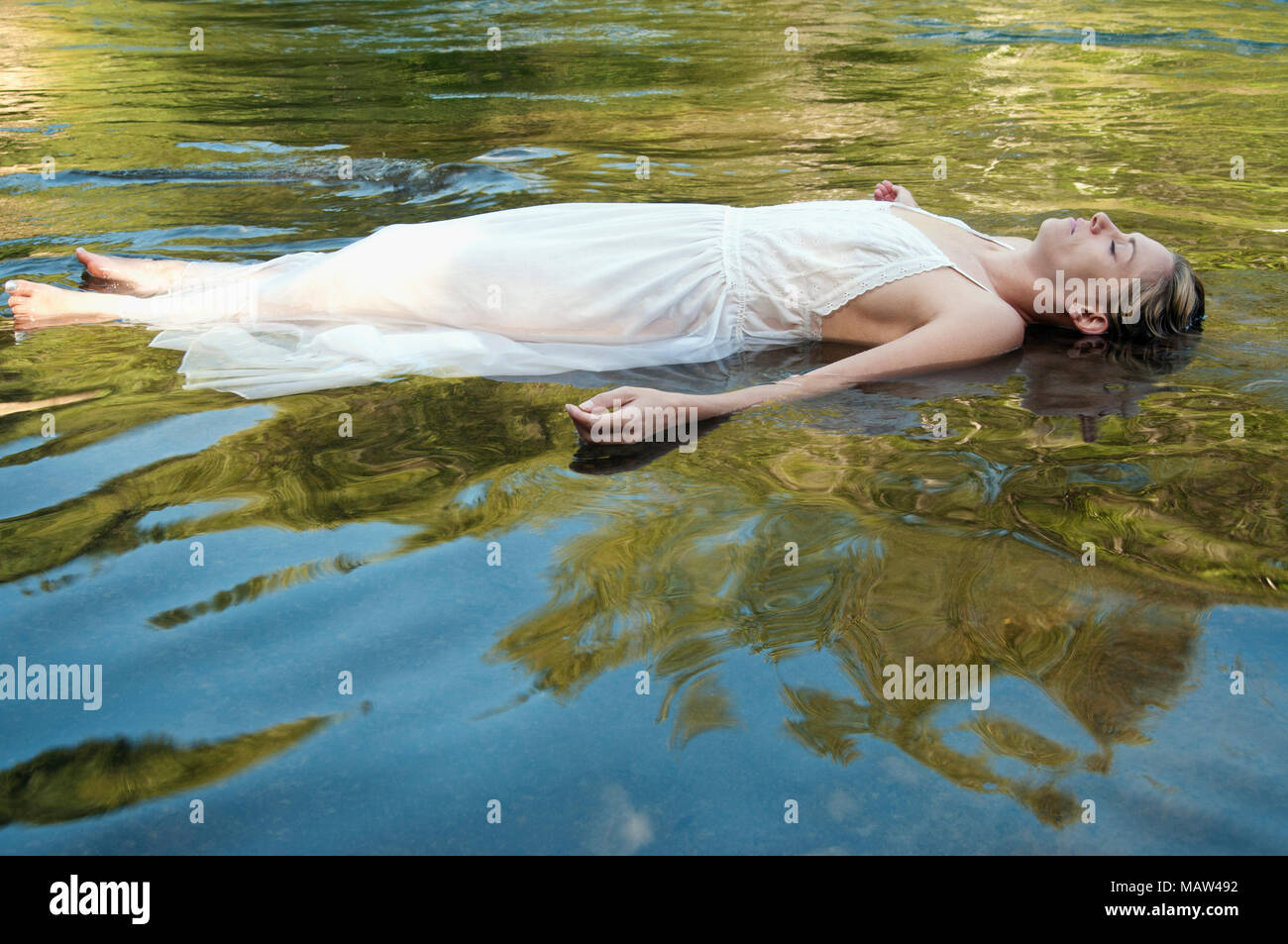 A woman laying down in water Stock Photo