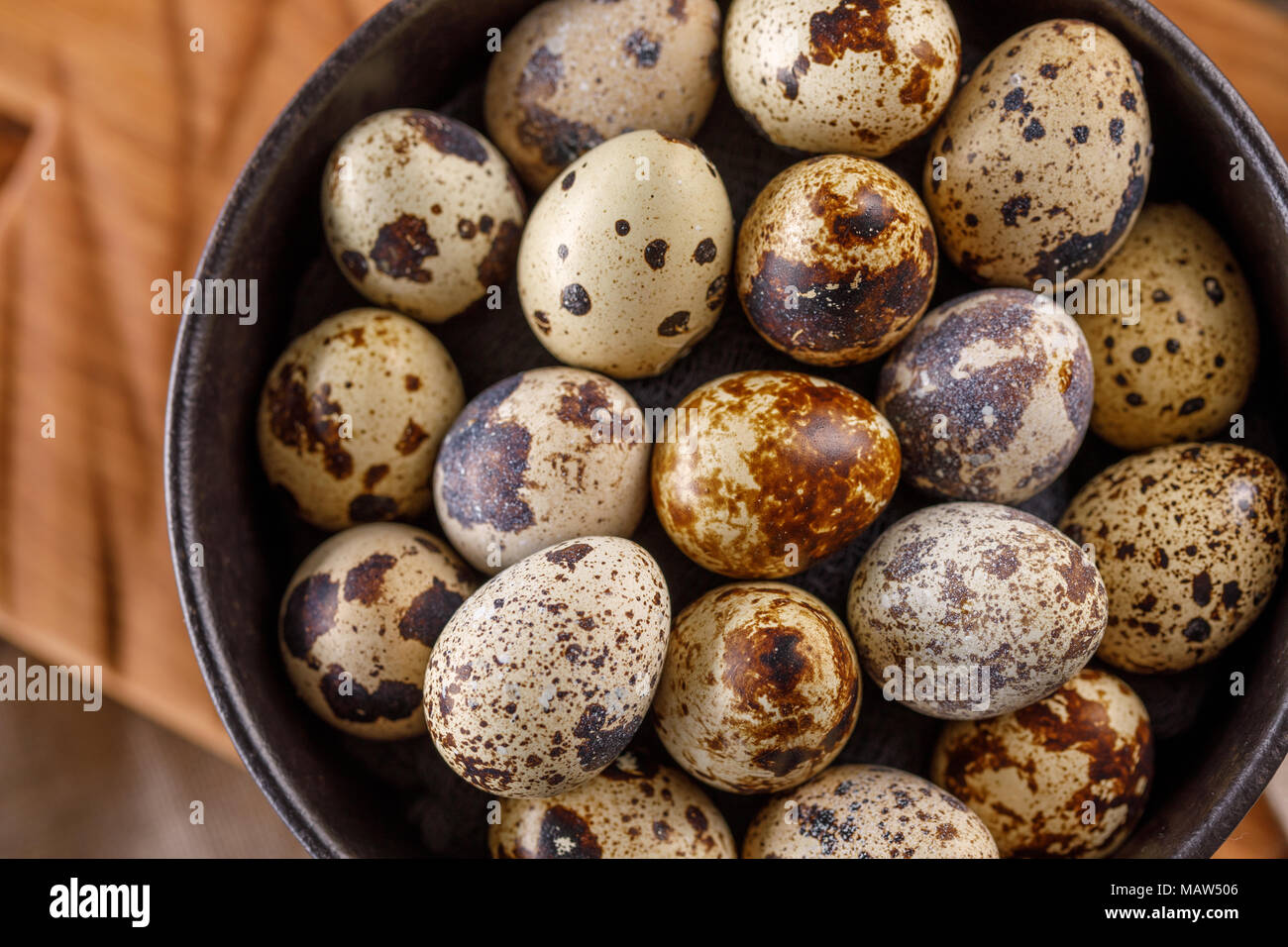 Quail eggs in a black cup close-up. A lot of quail eggs in a cup. Stock Photo