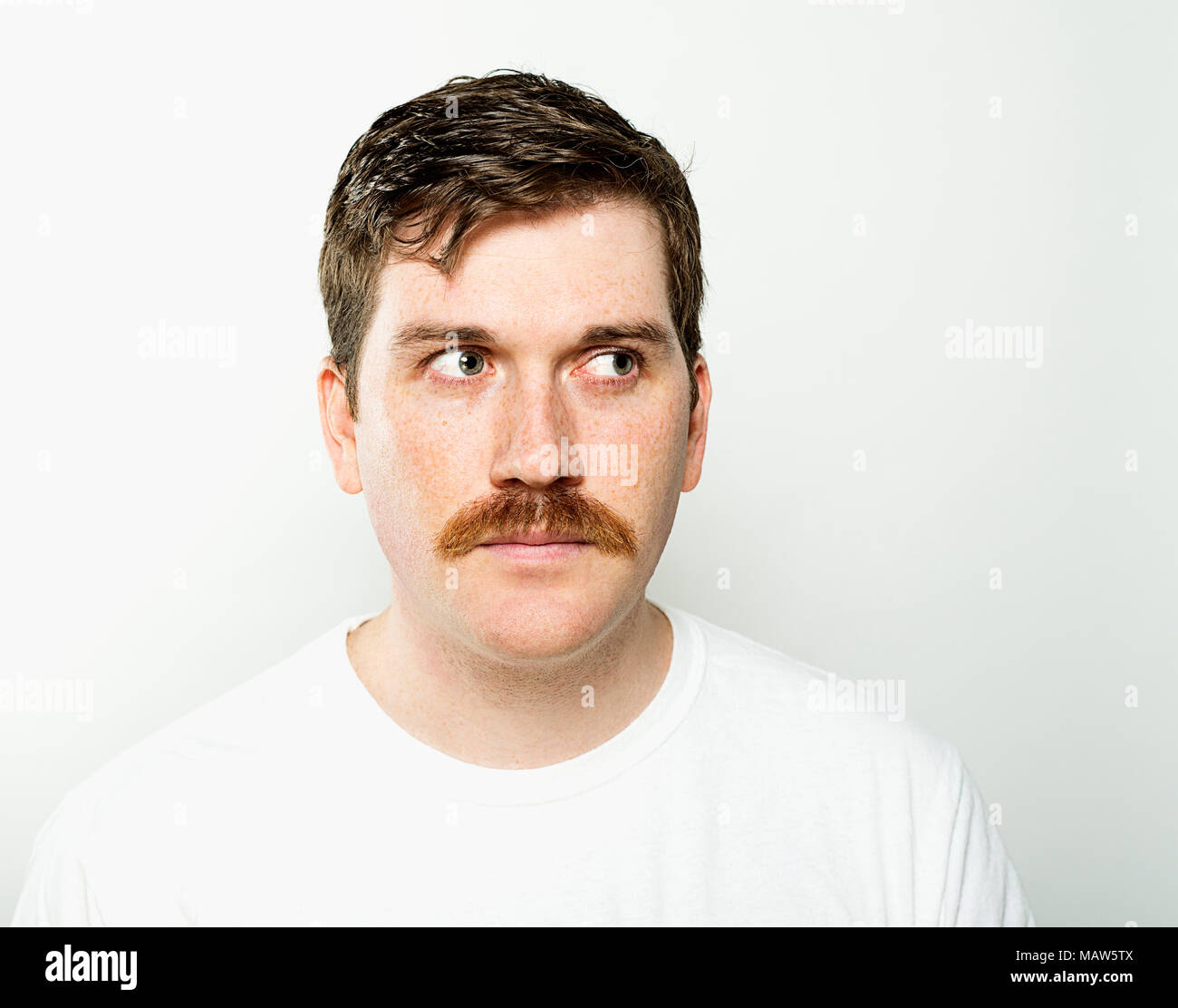 A man with freckles side eyeing. Stock Photo