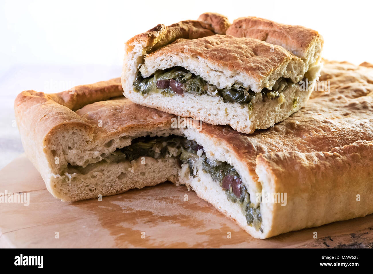 Pizza stuffed with escarole, olives and capers, slice and whole