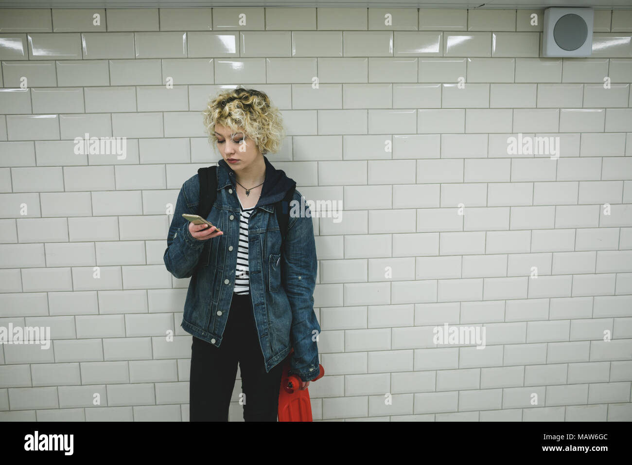 Woman using mobile phone in subway Stock Photo