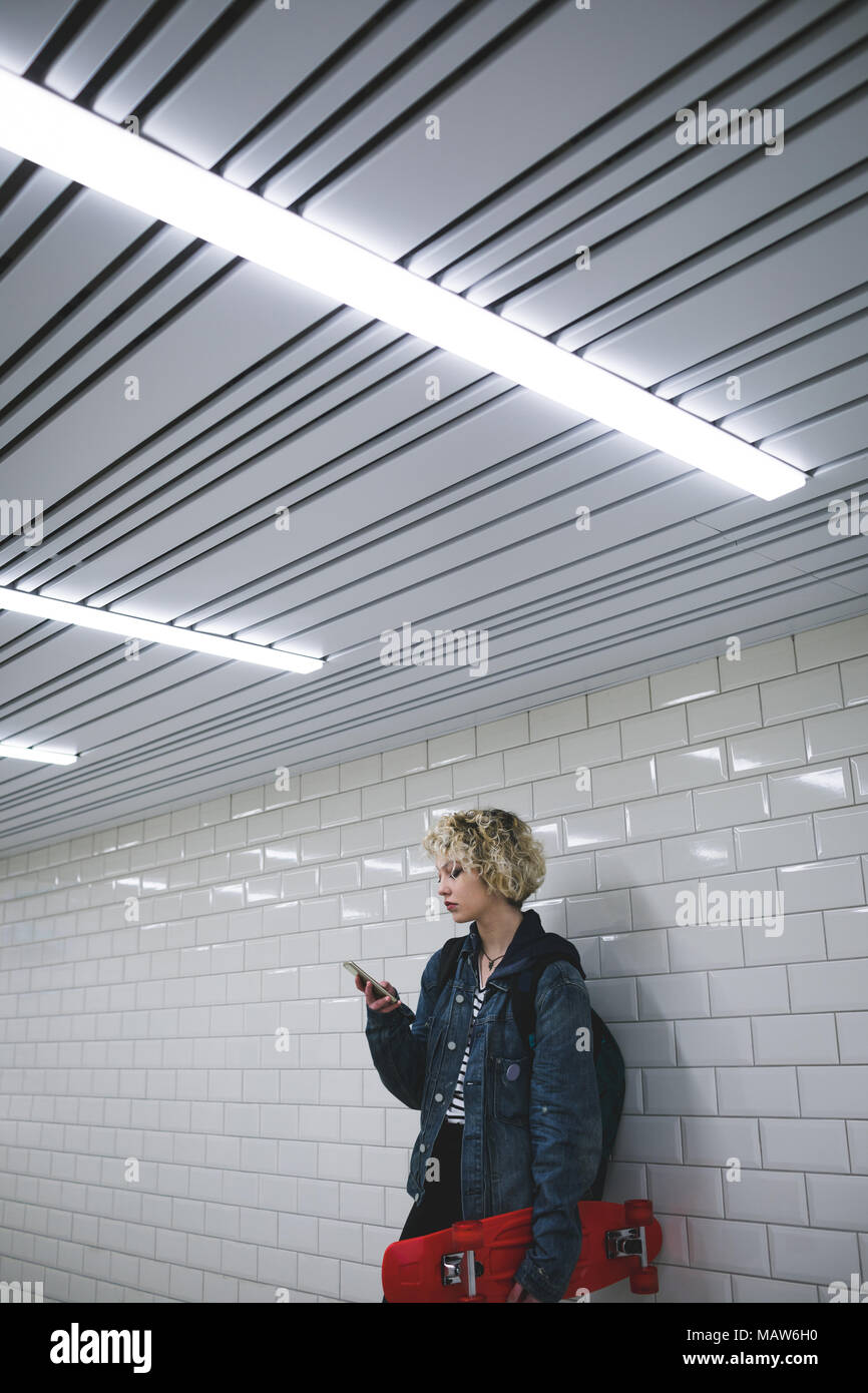 Woman using mobile phone in subway Stock Photo