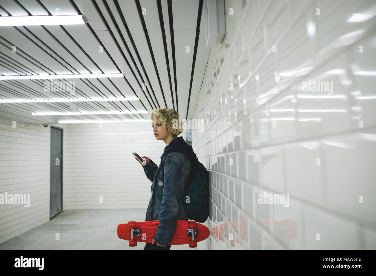 Woman using mobile phone in subway Stock Photo