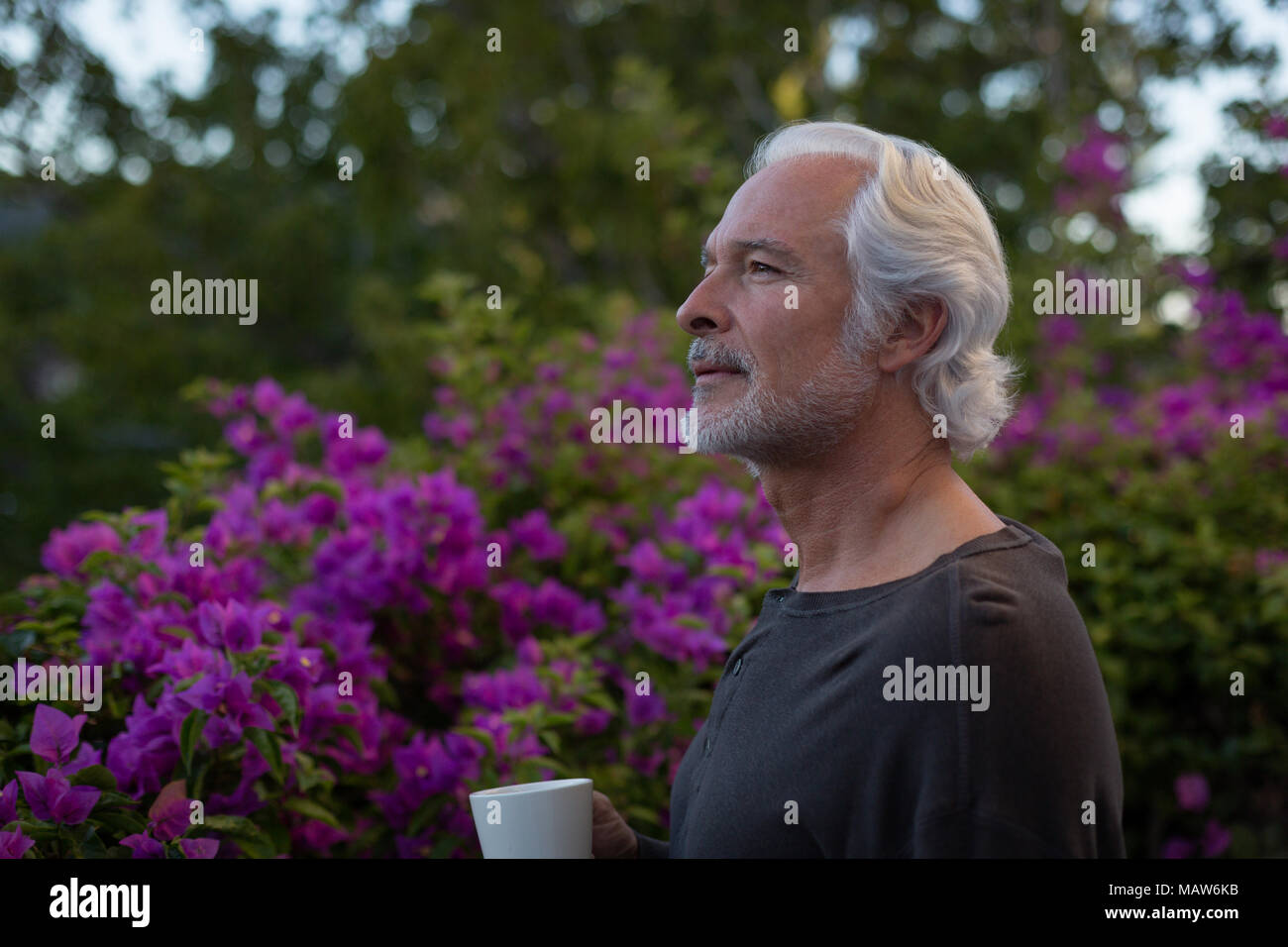Senior man having coffee in balcony Stock Photo