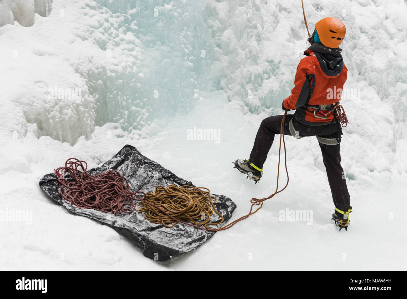 Female rock climber holding a rope during winter Stock Photo