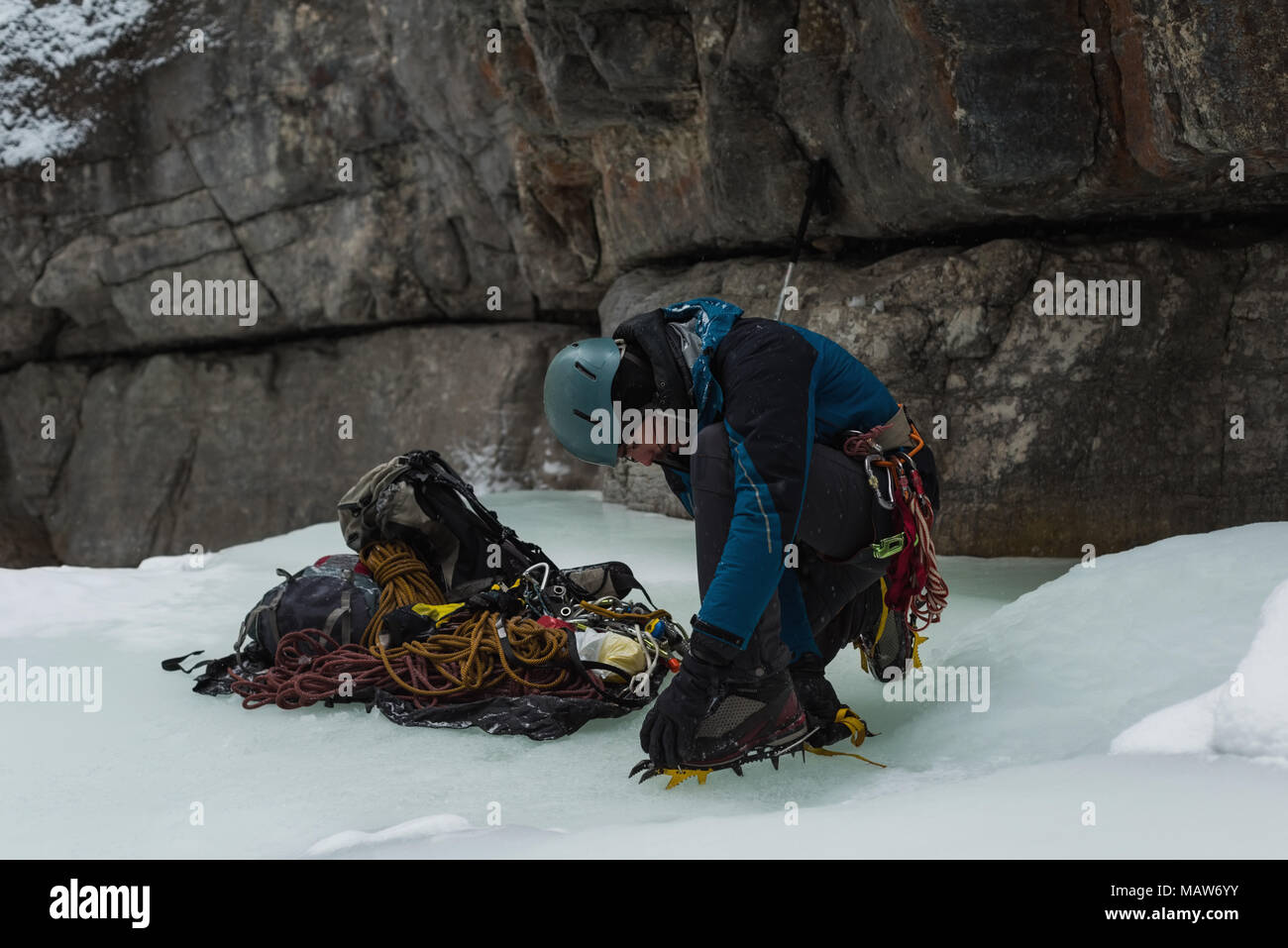 Male rock climber wearing crampons near rocky mountain Stock Photo