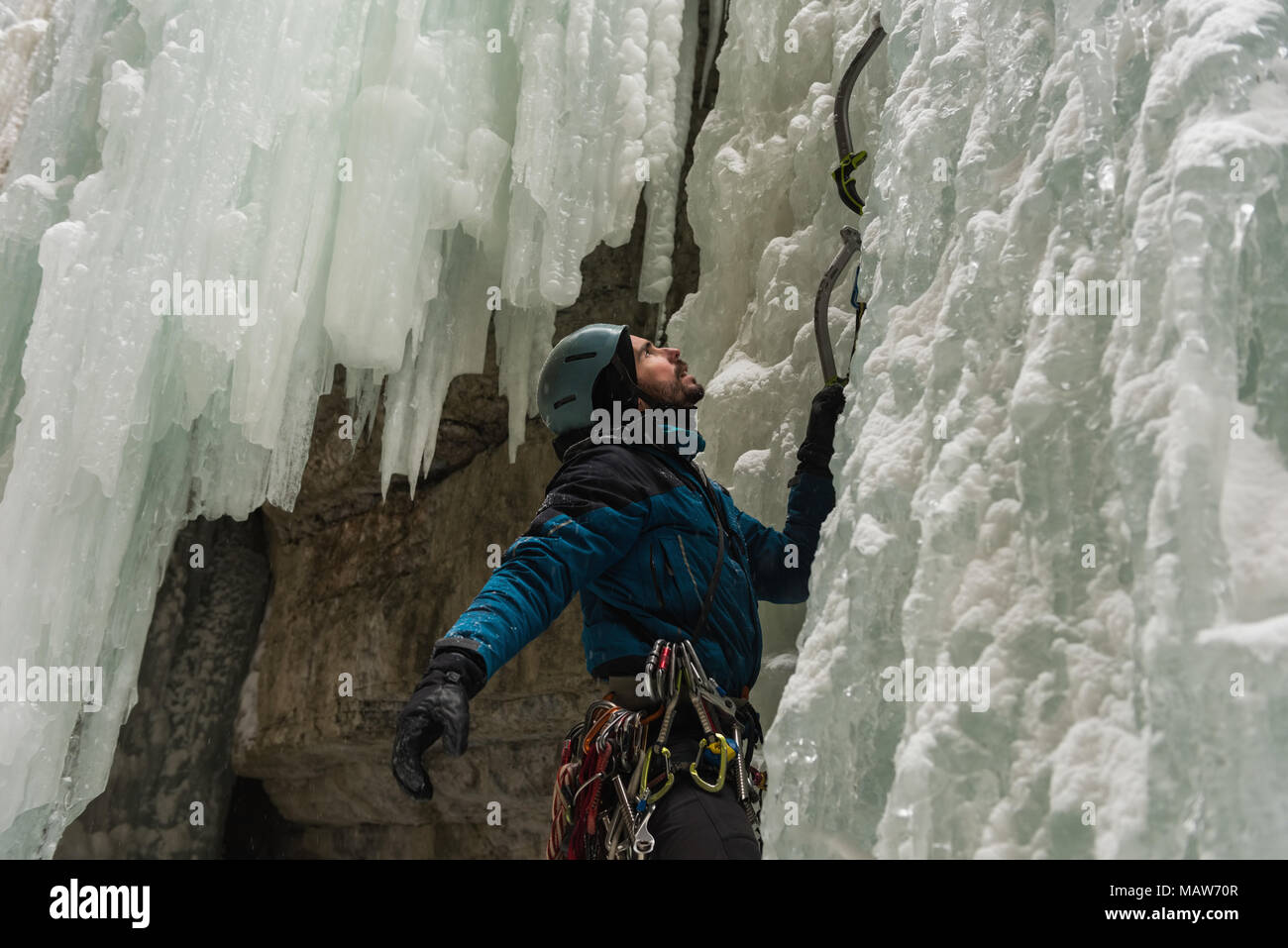 Male rock climber climbing ice mountain Stock Photo