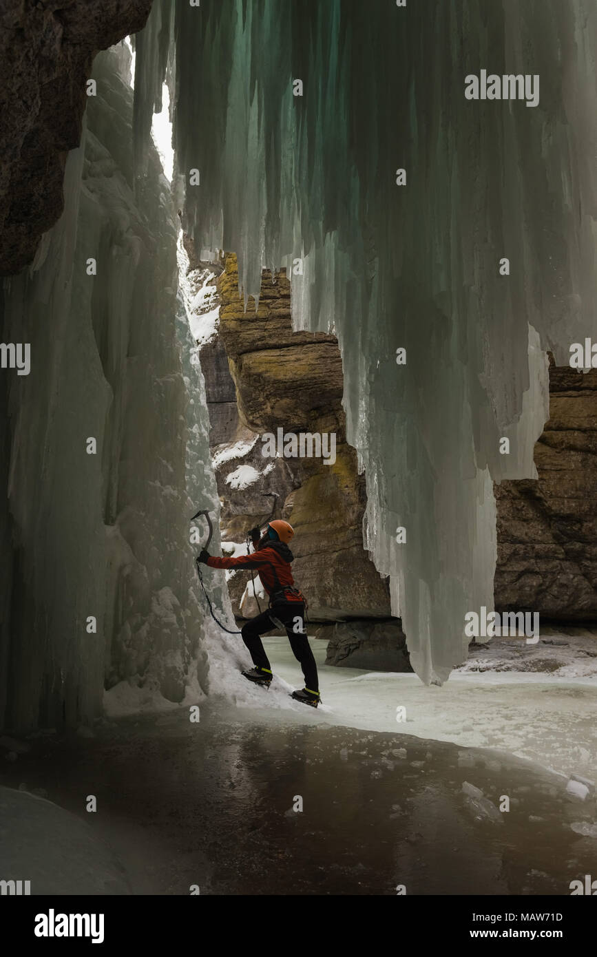Female rock climber climbing rocky ice mountain Stock Photo - Alamy