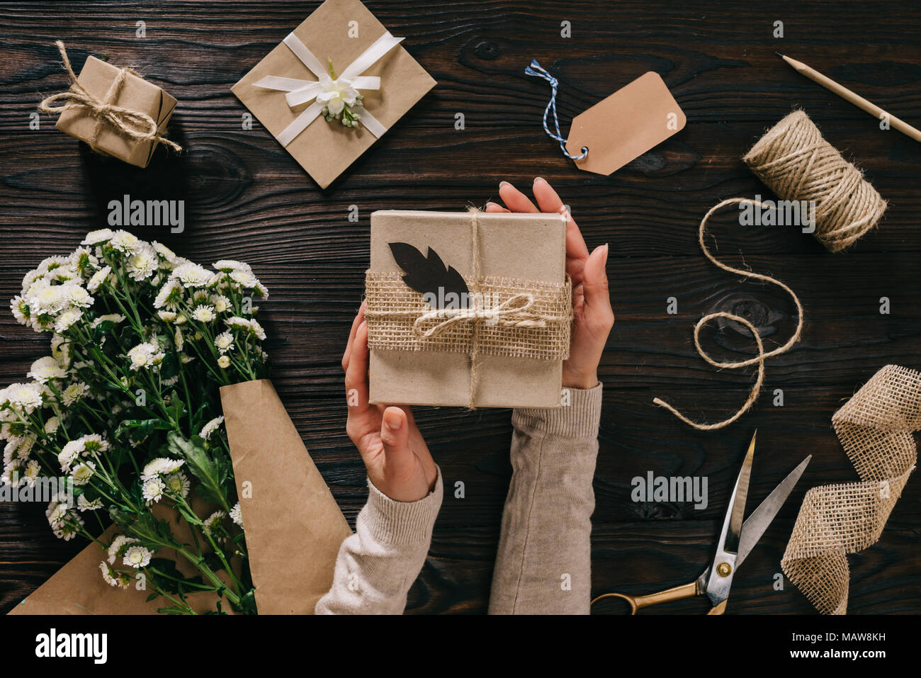 Partial View Of Woman Holding Gift With Flowers And Decoration