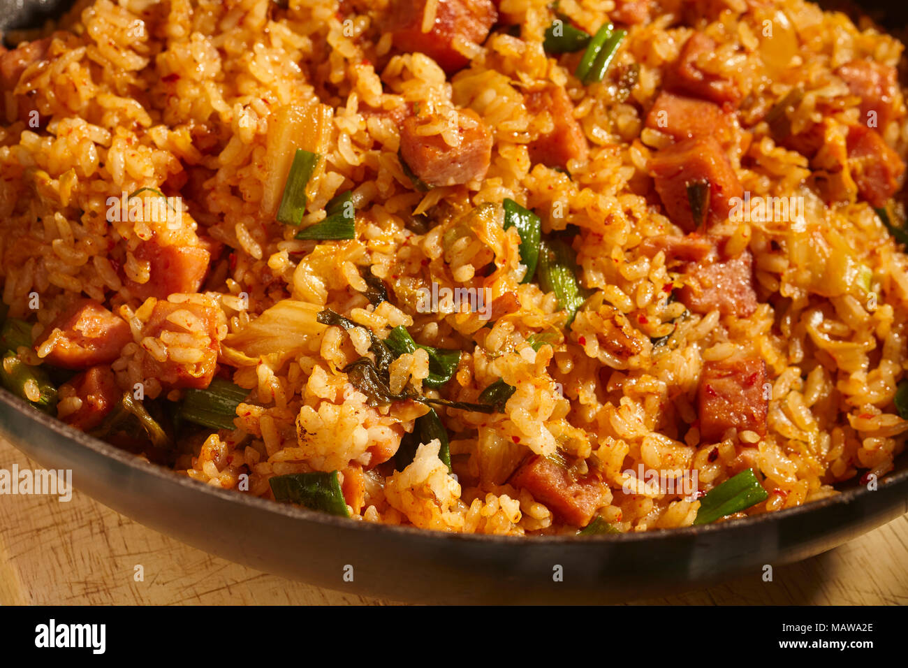 Spam and Kimchi fried rice in a black steel wok, a classic dish in Korean home cooking Stock Photo