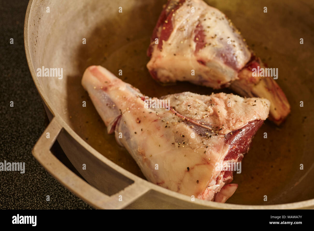 two lamb shanks searing in a pot Stock Photo