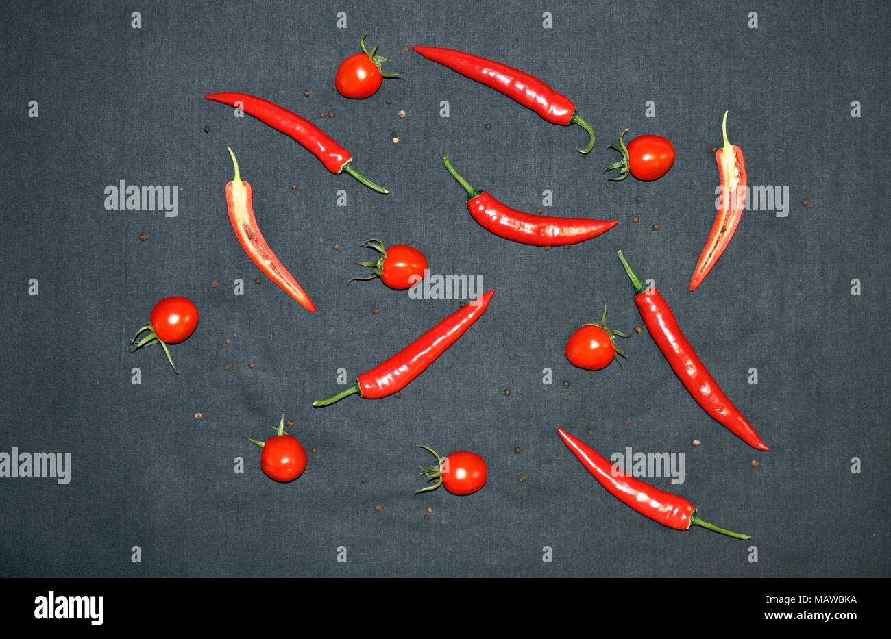Hot chilli, pepper and tomatoes on black background, top view, minimalist style Stock Photo