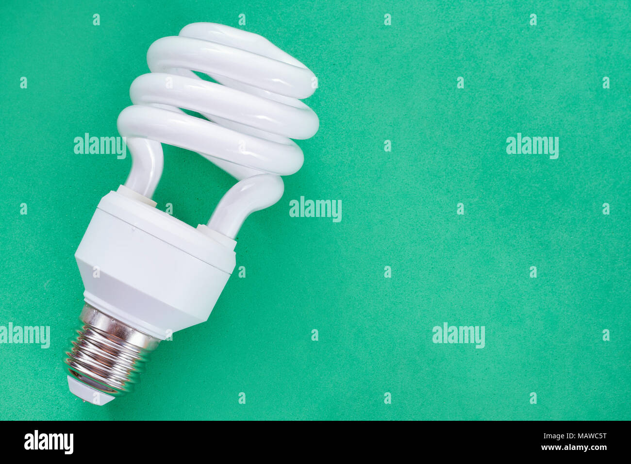 Fluorescent light bulb on green background, technology that contains