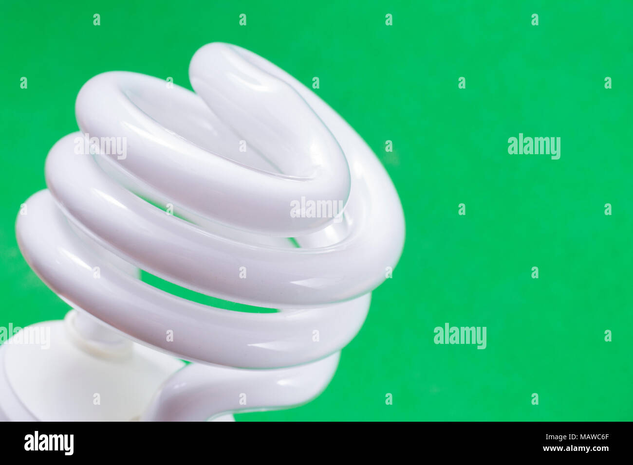 Fluorescent light bulb on green background, technology that contains